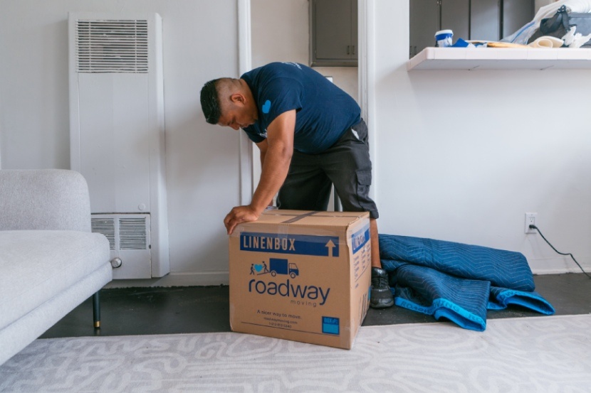 Roadway Moving's mover packing a box during a move in NYC