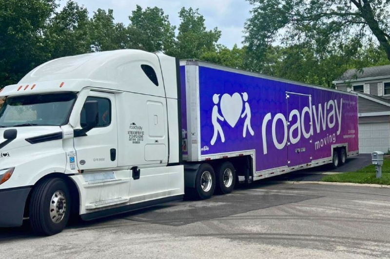 Roadway Moving's long distance truck trailer delivering a long distance move in front of customer's new house