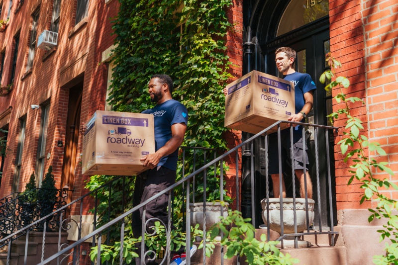 Roadway Moving's team carrying boxes outside an apartment in NYC