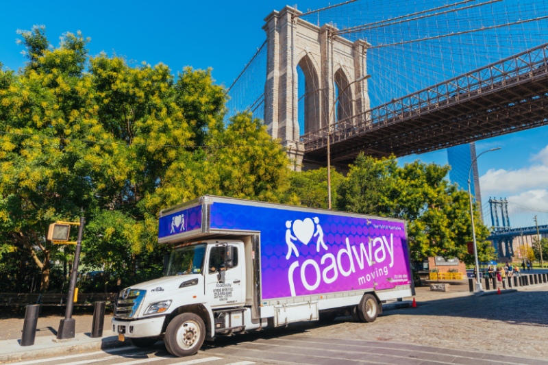 Roadway Moving's truck parked below the Brooklyn Bridge during a move